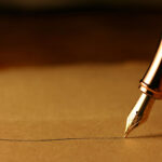A old fountain pen writes a signature on a contract paper.